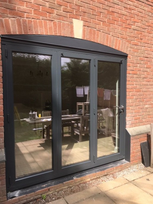 Origin Bi Fold Doors Installed in a Property, With an Orangery Installed in the Garden